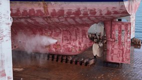 High-pressure water cleaning process on ship hull in dry dock for maintenance and rust removal. Essential marine engineering task for ship repair, safety, and performance. - Powered by Shutterstock - Get 15% off with code: PIKWIZARD15