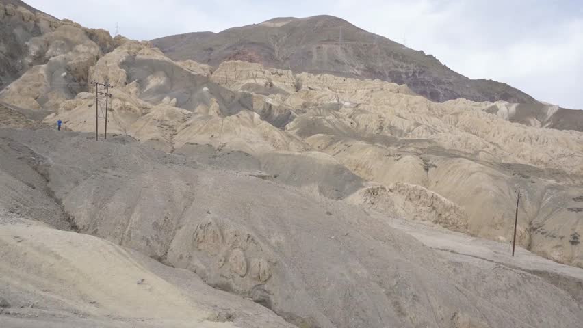 Rugged mountain landscape with winding road under a cloudy sky in remote region