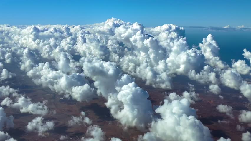 An immersive fighter jet POV from cockpit while flying at supersonic speed over tiny cottony cumulus clouds over a coastal landscape. Daylight. Ultra-realistic 4K shot.