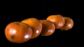 Five fresh oranges slowly spinning on barely visible strings against a black background. Minimalist citrus motion, clean rotating fruit concept for creative design, ads, and food footage. - Powered by Shutterstock - Get 15% off with code: PIKWIZARD15