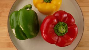 Fresh red, green and yellow bell peppers in a plate rotating top view.  - Powered by Shutterstock - Get 15% off with code: PIKWIZARD15