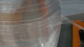 Stretch film is tightly wrapped around a pallet of boxes in a warehouse setting, efficient packaging and secure storage. The clear film encases the items, ensuring stability during transit. - Powered by Shutterstock - Get 15% off with code: PIKWIZARD15