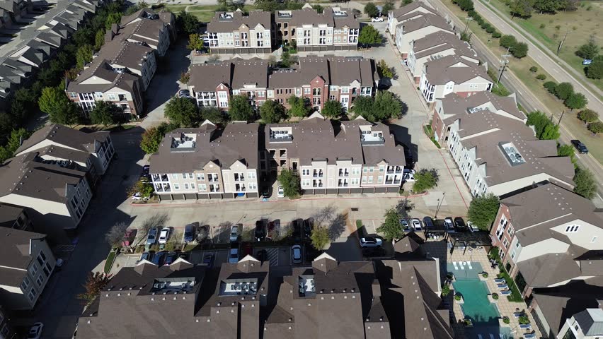 Multistory apartment buildings with brown roofs, brick accents, balconies, swimming pool, lounge area, River Walk Drive. Rooftop HVAC units zoned climate control, Flower Mound, Denton County, TX. USA