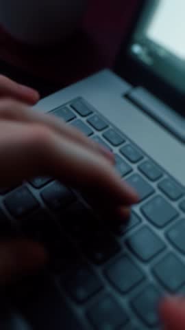 Close-up of hands typing on laptop keyboard
