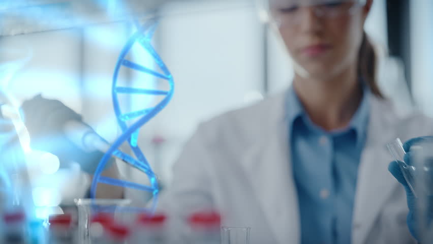 Focused Female Biochemist in Goggles Pipettes Medical Liquid Into Test Tube. DNA Hologram. Advanced Gene Therapy Development, Molecular Diagnostics, Precision Pharmaceutical Innovation in Laboratory.