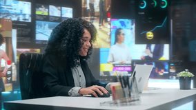 Smiling Young Black Woman Social Media Manager Works on Laptop in Office. Internet Use Concept with Immersive Feeds, Analytics Dashboards, Video Games and Content. 360 Degree Tracking Arc Shot - Powered by Shutterstock - Get 15% off with code: PIKWIZARD15