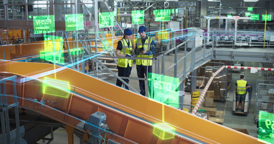 Two White Warehouse Specialists Stand Above Conveyors, Using a Digital Tablet and Holographic Parcel Data Visualisations to Control Automated Parcel Delivery, Monitor Analytics, Distribution Facility
