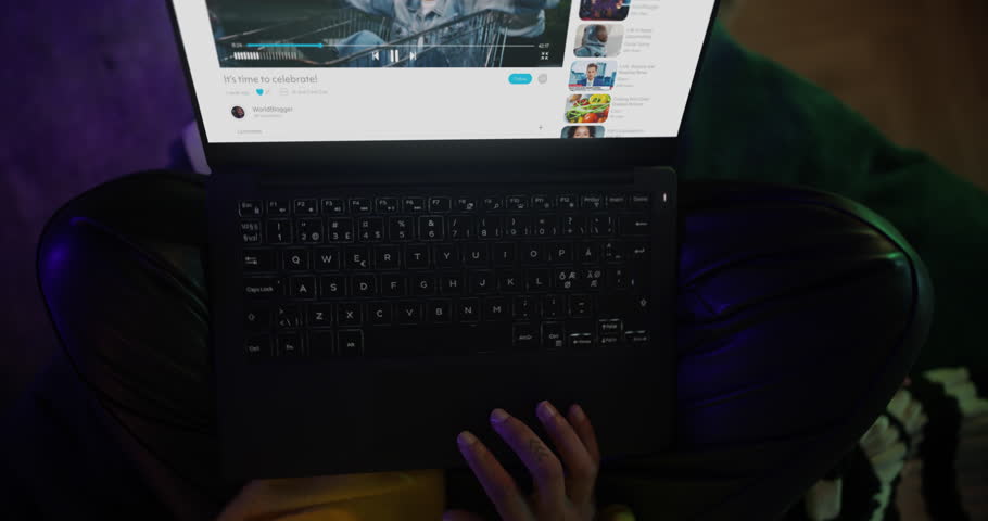 Woman in a Cozy Neon Bedroom Browses Social Media and Streaming Sites on Her Laptop, Surrounded by Floating Digital Immersive Online Content, Entertainment. Rotating Cinematic Robot Camera Movement