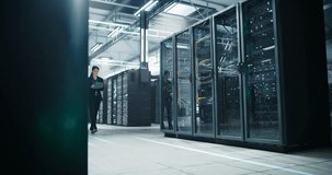 Female IT Professional Walks Through Hyperscale Data Center, Monitoring Tablet Readouts While Animated Infographics Overlay Glass Server Racks, Visualizing Cloud Capacity - Powered by Shutterstock - Get 15% off with code: PIKWIZARD15