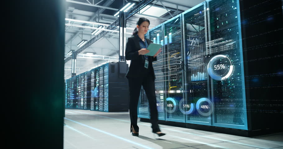 Female IT Professional Walks Through Hyperscale Data Center, Monitoring Tablet Readouts While Animated Infographics Overlay Glass Server Racks, Visualizing Cloud Capacity