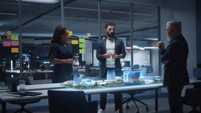 Architects Collaborate Late in a Glass Office, Reviewing a Holographic Smart City Model, Futuristic Skyline Concepts, Sustainable Master Planning, and High Tech Urban Development Strategy Together. - Powered by Shutterstock - Get 15% off with code: PIKWIZARD15