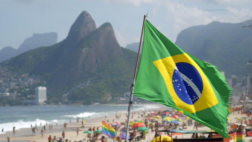Brazilian flag waving in the wind on Ipanema Beach in Rio de Janeiro, Brazil.