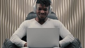 African American man typing laptop smiling carefree in futuristic studio male guy using computer futurism cyberspace technology joyful playing virtual game wearing headphones in innovative studio - Powered by Shutterstock - Get 15% off with code: PIKWIZARD15