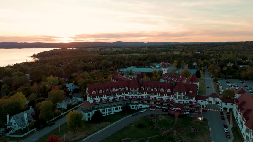 An aerial view of the Algonquin Resort in St Andrews by the Sea, New Brunswick, Canada, at warm sunset light over trees, coastline, and calm water