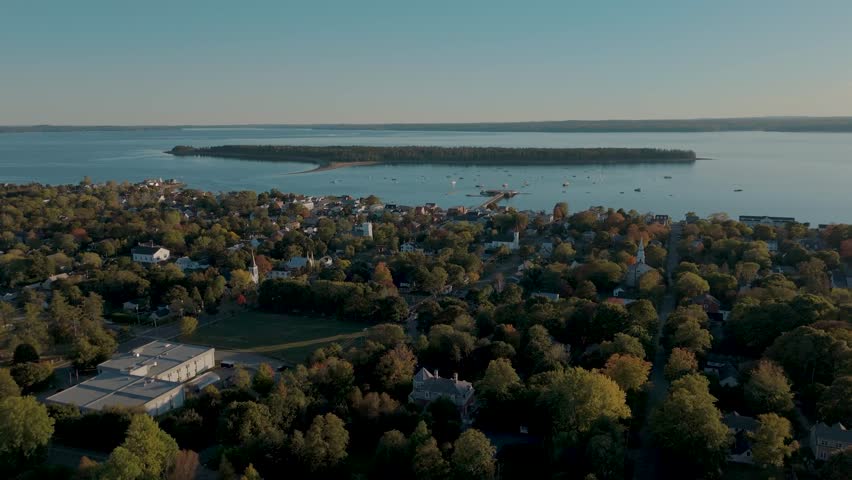 An aerial drone view of St Andrews by the Sea in New Brunswick, Canada, showing its coastal homes, church steeples, and the harbor with boats