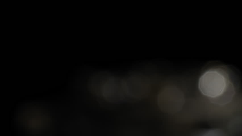Small blurred lights moving on a black background 