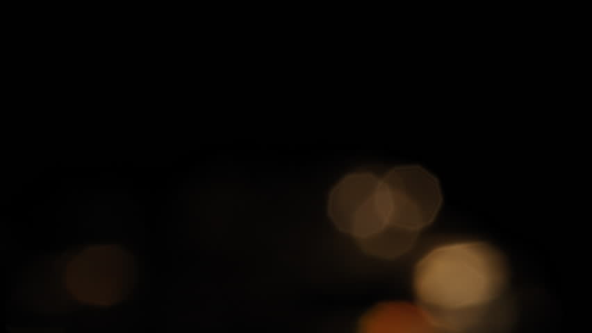 Small blurred lights moving on a black background 