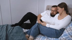 A loving couple, relaxing in bed, exchanging interesting conversations and impressions, browsing social networks through a smartphone and spending quality leisure time together at home - Powered by Shutterstock - Get 15% off with code: PIKWIZARD15