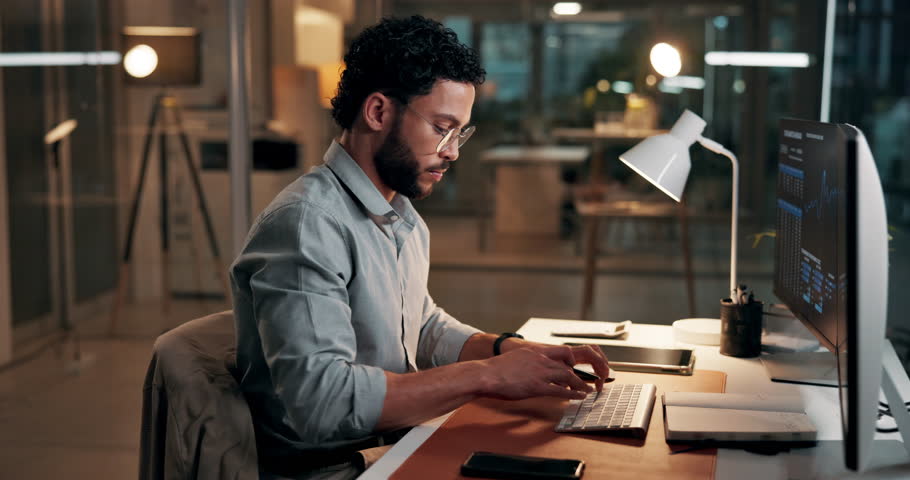 Man, computer screen and writing with trading, graphs and stock market stats with notes at night. Person, trader and pc monitor with charts, fintech or review with book for investment at dark office