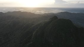 Aerial drone shot of a golden sunrise glowing over a series of dark mountain ridges, revealing dramatic contours and a vast landscape in soft morning light. - Powered by Shutterstock - Get 15% off with code: PIKWIZARD15