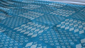 Slow motion video of a female hand folding a soft white towel on a bed with a blue duvet cover inside a hotel room with natural light.  - Powered by Shutterstock - Get 15% off with code: PIKWIZARD15