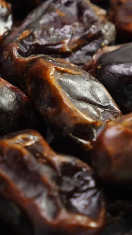 Dates fruit background. Dried date, closeup. Nobody. Top view. Rotate. Vertical footage