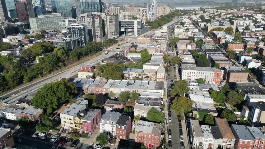 Overhead look at Jersey City rooftops and intersecting roads showing shadows, structure lines, and dense residential formations.