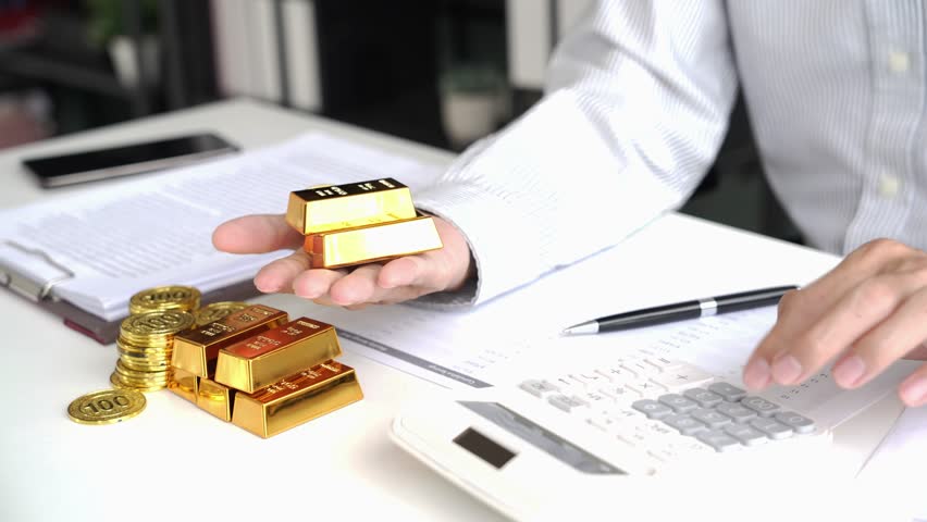 Gold Trading Businessman invest in trading gold, calculating profit price for buy and sell gold