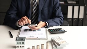 Investing in Real Estate, Real estate agent or investor calculating, planning, analyzing financial data for property investment. Themes of saving, investing, financial aspects of purchasing a home. - Powered by Shutterstock - Get 15% off with code: PIKWIZARD15