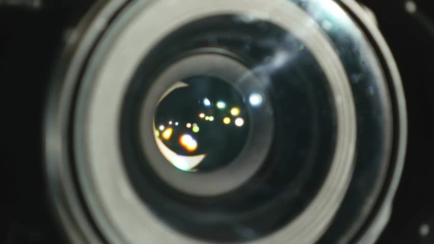 professional video camera lens. The lens coatings and intricate details are visible. open and close the aperture of the camera to adjusting, close-up.