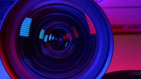 Camera lens Decorated with a colorful red and blue light background. Gradually zooming the camera lens, close-up. Detail of focus of the camera lens. - Powered by Shutterstock - Get 15% off with code: PIKWIZARD15