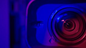 Detailed focus of the video camera lens with red light background. Black professional camera lens, close-up. a working camera lens while zooming in. - Powered by Shutterstock - Get 15% off with code: PIKWIZARD15