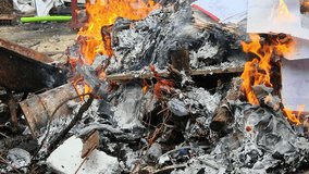 Piles of paper archives and documents burn outdoors in a controlled fire, destroying old files for security or disposal. The image shows flames, ash, and smoke in an exterior cleanup process. - Powered by Shutterstock - Get 15% off with code: PIKWIZARD15