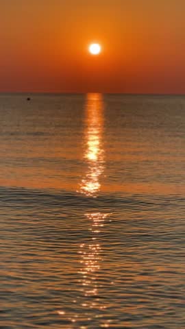 Golden sun rising over the calm ocean waves