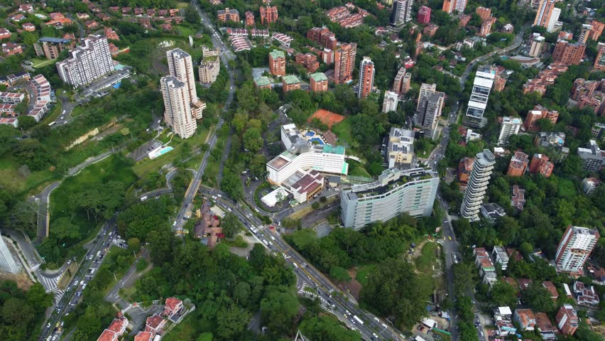 El Poblado Medellin view featuring hotel tower, Avenida Las Palmas, modern buildings, green hills and bright daylight cityscape, showing a panoramic urban scene with vibrant atmosphere todaynowup