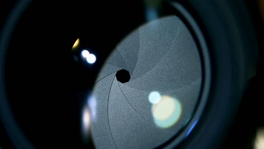 Shot of Diaphragm blades of fixed camera lens opening and closing aperture. Closing and opening Aperture of film camera. Camera lens aperture close-up.
