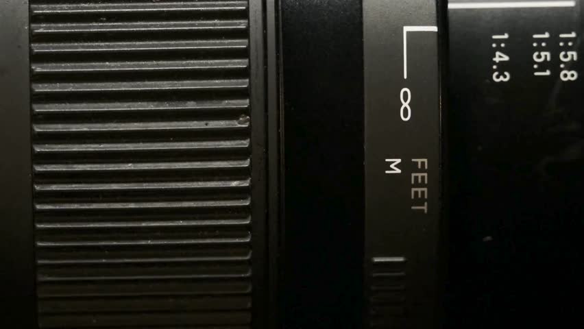 Macro-shot of camera lens focus scale. Adjusting the camera Manual Aperture. Detail on the lens scale of a camera while the zoom wheel is turning.