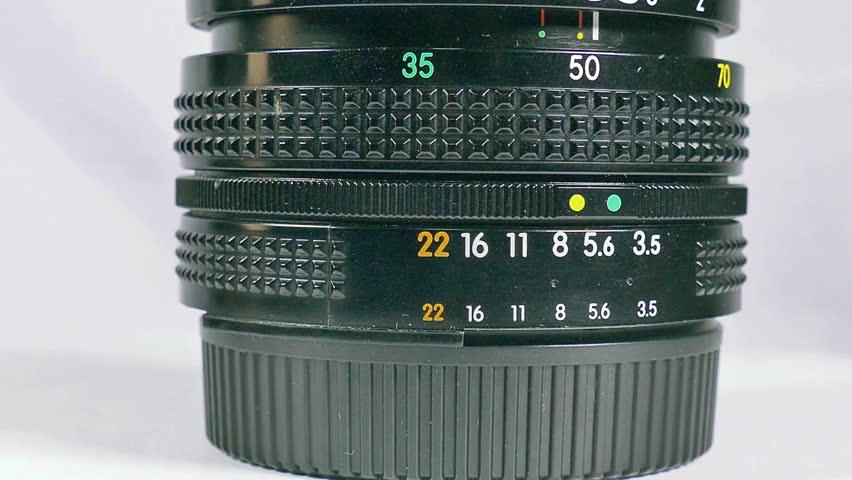Macro-shot of camera lens focus scale. Adjusting the camera Manual Aperture. Detail on the lens scale of a camera while the zoom wheel is turning.