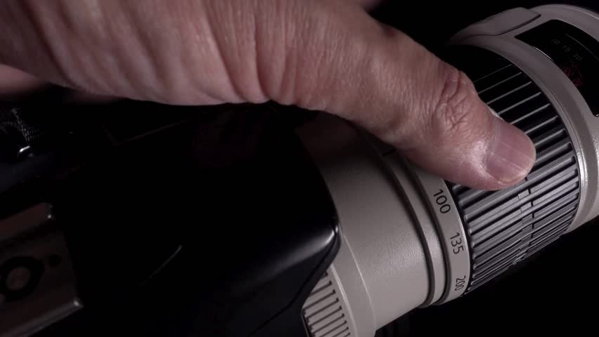 Photographer hand changing manual aperture ring on the camera lens. Lens camera manual focus. Changing exposure with aperture ring on manual lens.