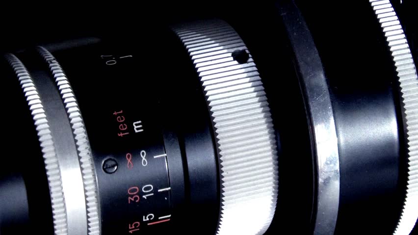 Macro-shot of camera lens focus scale. Adjusting the camera Manual Aperture. Detail on the lens scale of a camera while the zoom wheel is turning.