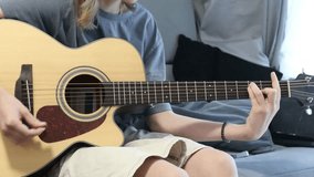 Horizontal video of a teen playing acoustic guitar, practicing chords in a relaxed home setting—ideal for trending music-education content and beginner-learning platforms - Powered by Shutterstock - Get 15% off with code: PIKWIZARD15