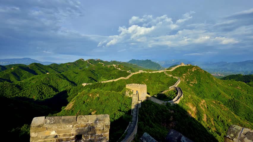 Explore the breathtaking aerial view of the Great Wall of China stretching across lush hills and ancient towers near Beijing