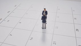 Two Miniature Business Figures Are Discussing Business Plans And Upcoming Appointments On A White Calendar Page, Captured In A Detailed Macro Shot Under Even Artificial Lighting. - Powered by Shutterstock - Get 15% off with code: PIKWIZARD15