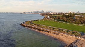 Smooth rising drone shot overlooking Point Ormond Lookout and the coastline, revealing the Melbourne city skyline at golden hour. - Powered by Shutterstock - Get 15% off with code: PIKWIZARD15