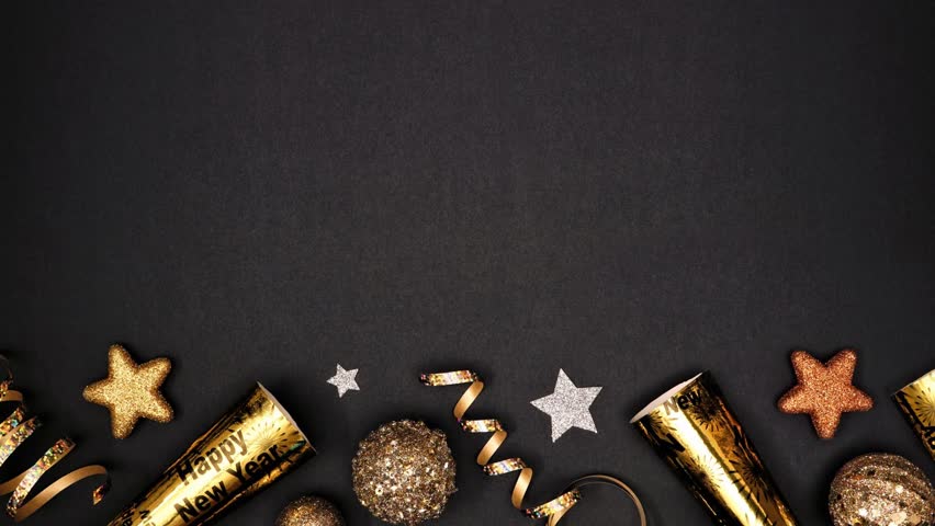 New Years Eve moving bottom border of glittery gold stars, streamers, decorations and noisemakers. Stop motion loop video. Above view on a black background.