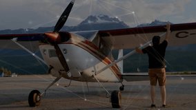 Pilot performing preflight visual checks on right wing and cabin door before boarding aircraft. Airplane, highwing, propeller, airfield, apron, runway, mountains - Powered by Shutterstock - Get 15% off with code: PIKWIZARD15