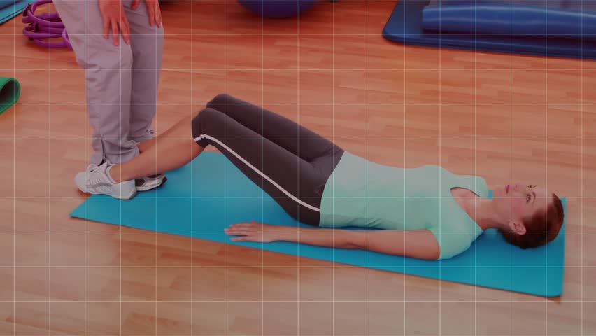 Female participant performing crunches on mat after trainer cue, bar-graph overlay tracking fitness. Abs, core, workout, gym, studio, training, duo