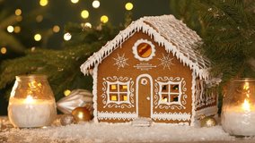 Beautiful gingerbread house and Christmas decor on table under falling artificial snow against blurred lights, closeup. Bokeh effect - Powered by Shutterstock - Get 15% off with code: PIKWIZARD15