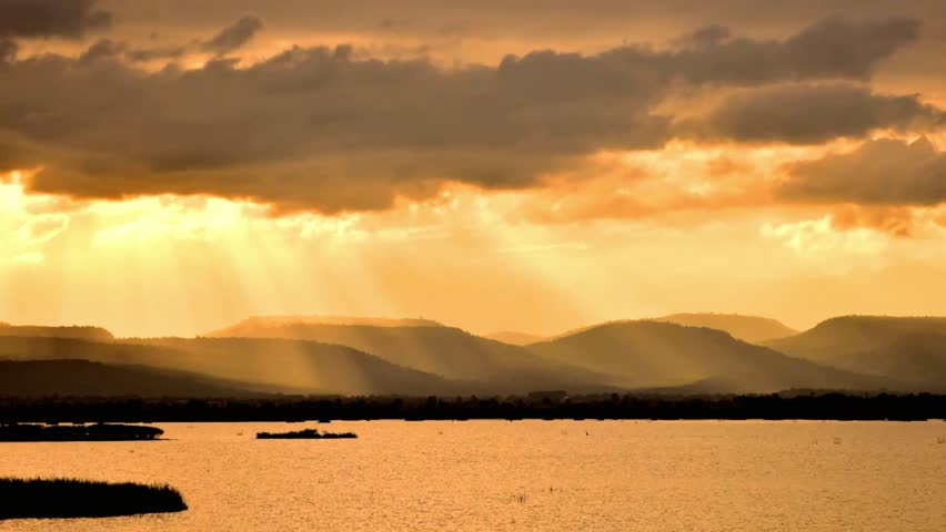 Golden sunset over a tranquil lake with mountains in the distance peaceful scene