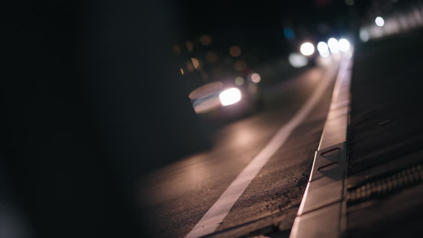 Cars Passing on Dark Road at Night